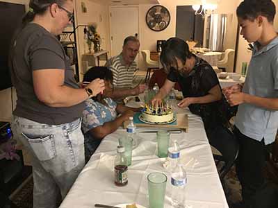 guests putting candles onto birthday cake