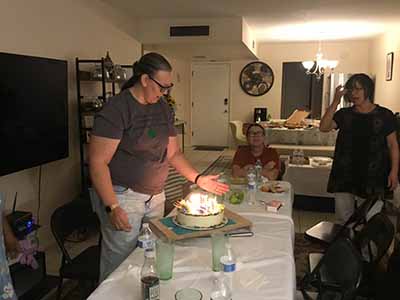 guests with birthday cake candles are lit