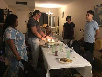guests with birthday cake candles are lit