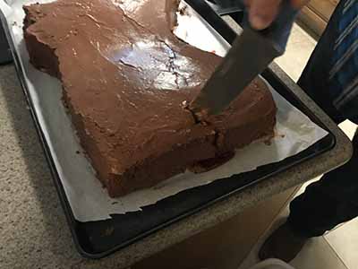 cutting into severed horse head cake