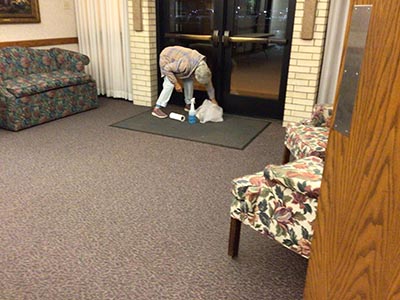 Debra cleaning glass doors in preparaton for a memorial service