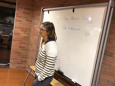 Tracy, book club leader, at whiteboard