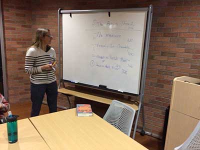 Tracy, book club leader, at whiteboard