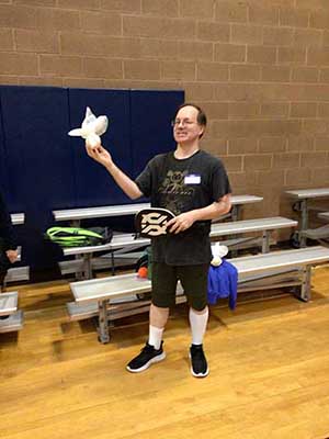 Preston holding graduation gift - a pickleball ball