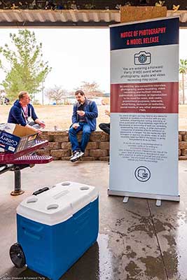 people talking next to photo consent sign