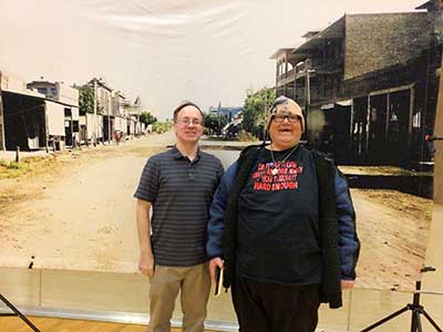 people posing in front of large photo of 1900 Tempe