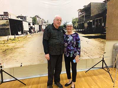 people posing in front of large photo of 1900 Tempe