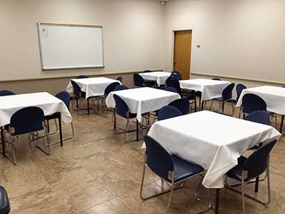 Prescott Room after setting up, table with white tablecloths