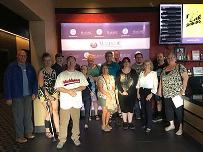 group photo of neighbors gathered in lobby of theater to watch movie The Creator