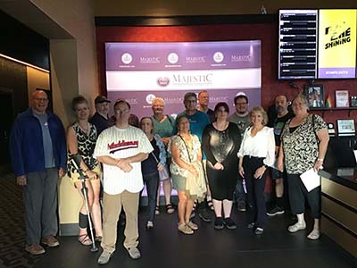 group photo of neighbors gathered in lobby of theater to watch movie The Creator