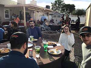neighbors gather at for Thanksgiving Day potluck dinner