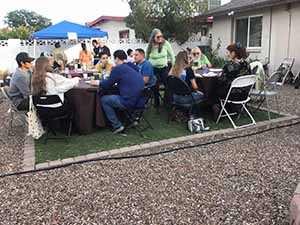 neighbors gather at for Thanksgiving Day potluck dinner