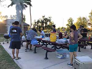 neighbors gather at park for potluck dinner birthday party