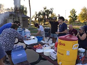neighbors gather at park for potluck dinner birthday party