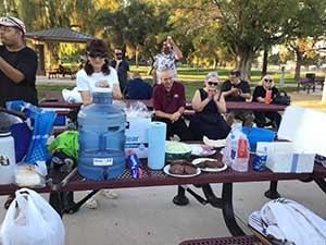 neighbors gather at park for potluck dinner birthday party