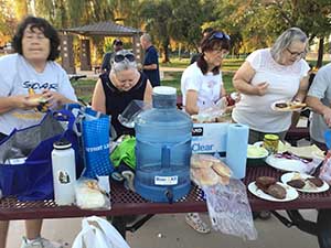 neighbors gather at park for potluck dinner birthday party
