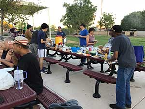 neighbors gather at park for potluck dinner birthday party