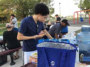 neighbors gather at park for potluck dinner birthday party