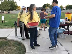 neighbors gather at park for potluck dinner birthday party