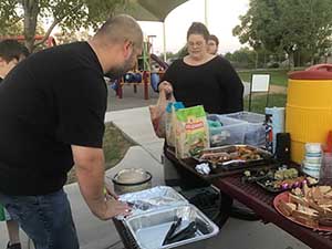 neighbors gather at park for potluck dinner birthday party