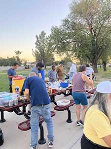 neighbors gather at park for potluck dinner birthday party