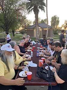 neighbors gather at park for potluck dinner birthday party