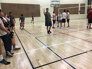 neighbors gather to play indoor volleyball