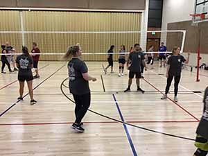 neighbors gather to play indoor volleyball