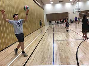 neighbors gather to play indoor volleyball