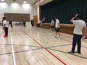 neighbors gather to play indoor volleyball
