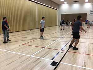 neighbors gather to play indoor volleyball