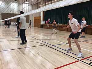 neighbors gather to play indoor volleyball