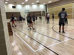 neighbors gather to play indoor volleyball