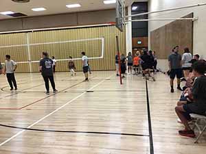 neighbors gather to play indoor volleyball